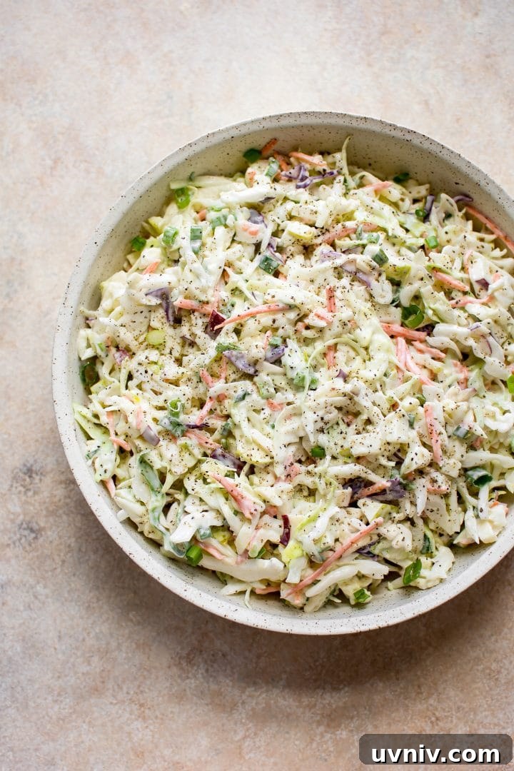 Crisp Apple Slaw Recipe with Tangy Honey-Mustard Dressing 4 apple and cabbage slaw with creamy dressing in a beige bowl