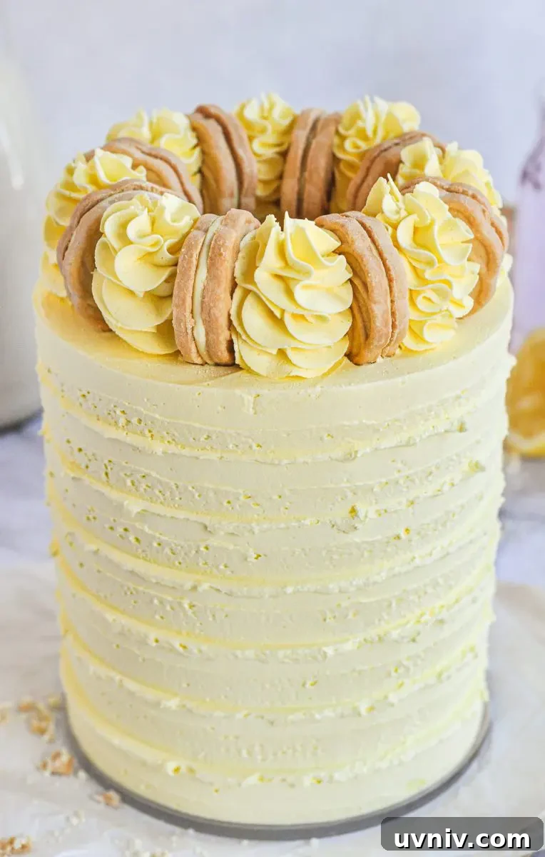 Pink Lemonade Cake Recipe: Light, Refreshing Layer Cake 2 A yellow cake with yellow frosting swirls on top and a golden cookie between each swirl.