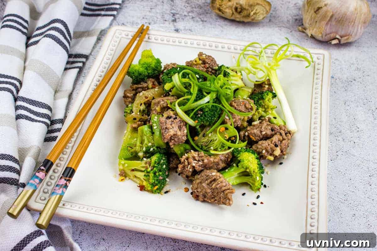 A plate of beef and broccoli with chopsticks.