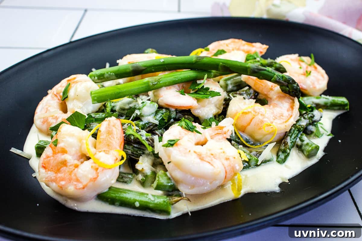 Shrimp & Asparagus Alfredo on a black plate.