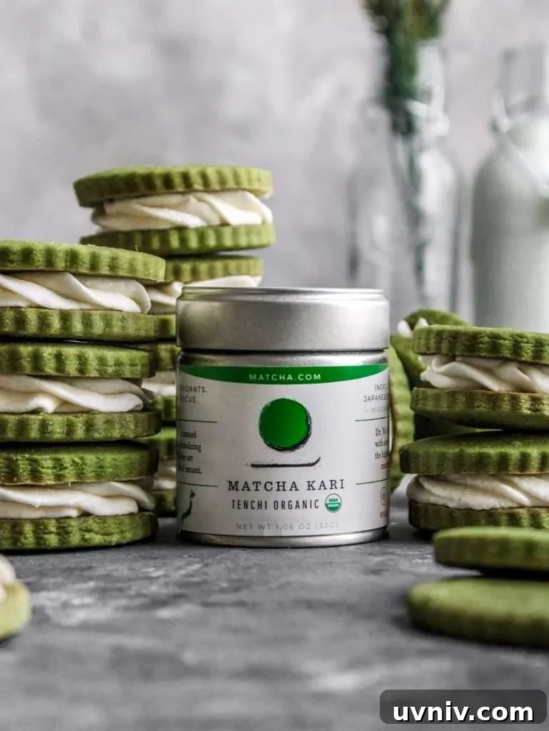 Matcha Cream Sandwich Cookies: Soft Green Tea Cookie Recipe 6 filled matcha sandwich cookies stacked around tin of matcha powder (1)