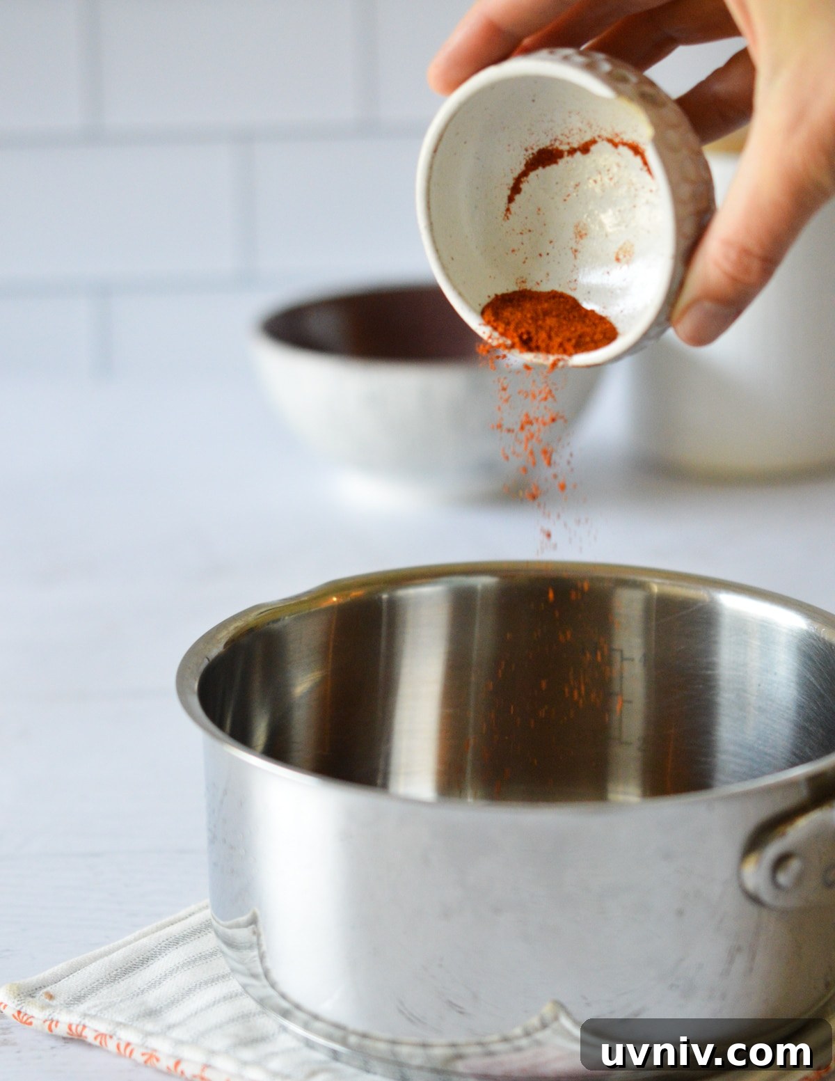 Spicy Maple Syrup Recipe: Sweet Heat for Breakfast & Glaze 5 pouring cayenne into a saucepan.