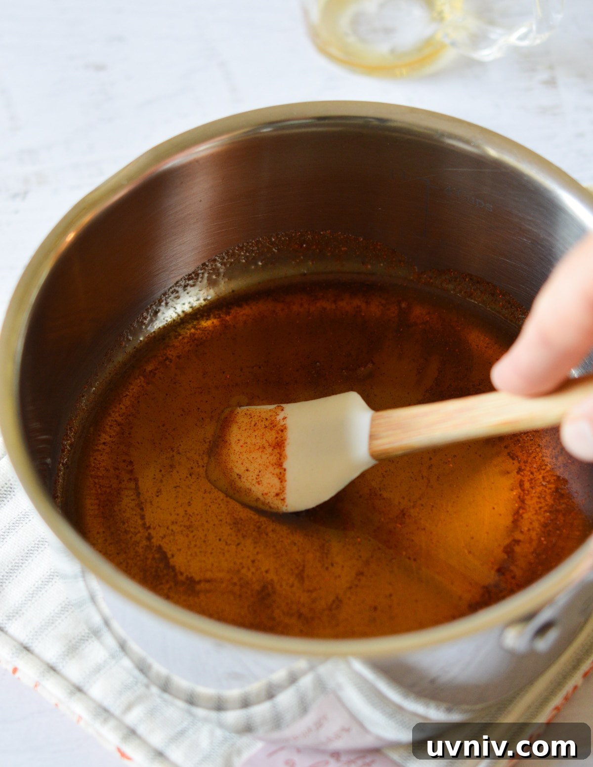 Spicy Maple Syrup Recipe: Sweet Heat for Breakfast & Glaze 6 spatula stirring maple syrup and cayenne.