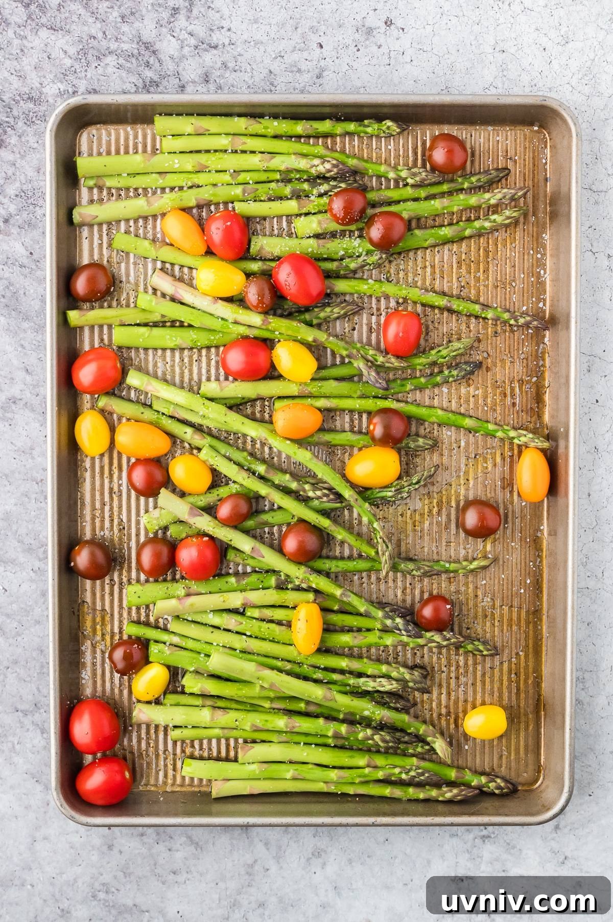 One-Pan Salmon and Roasted Asparagus Recipe 17 Asparagus and cherry tomatoes on a baking sheet, ready for roasting.