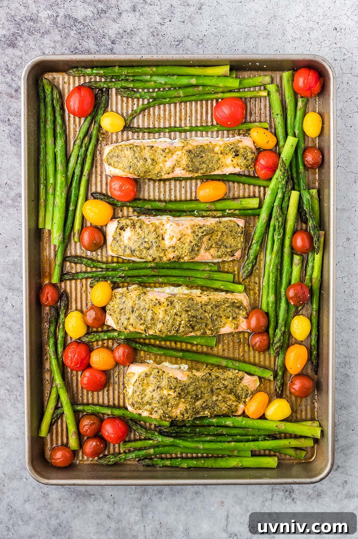 One-Pan Salmon and Roasted Asparagus Recipe 20 Enjoy Sheet Pan Salmon and Asparagus, featuring baked salmon fillets with pesto, tender asparagus, and vibrant cherry tomatoes—all roasted together for a simple yet delicious meal.