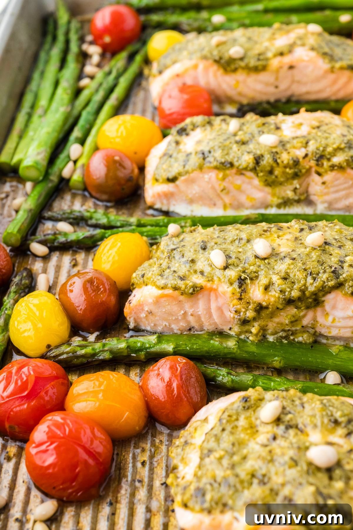 One-Pan Salmon and Roasted Asparagus Recipe 10 Baked salmon with pesto, asparagus, and roasted cherry tomatoes on a sheet pan, topped with pine nuts.