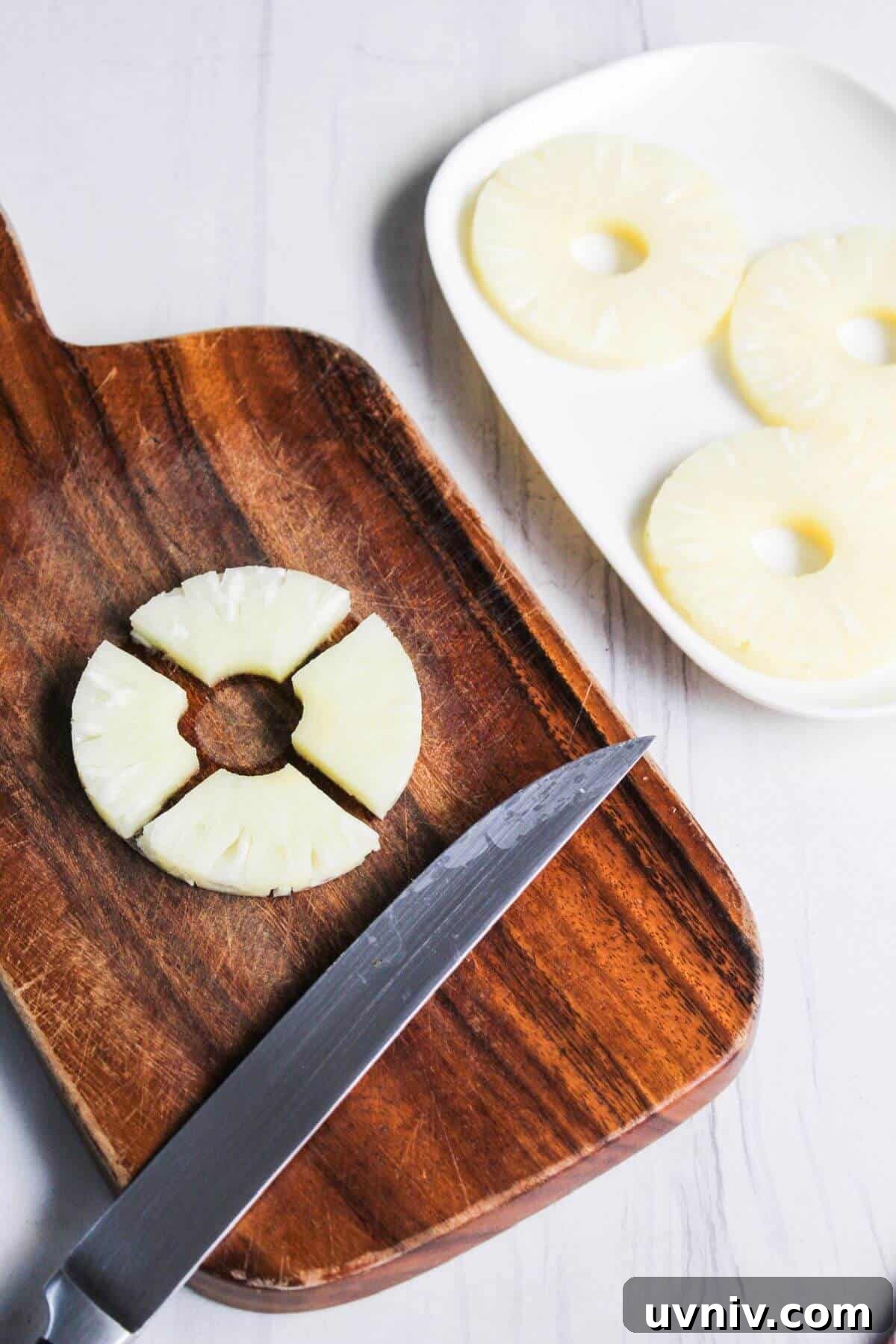 Crispy Caramelized Pineapple in the Air Fryer 4 Pineapple slices on a cutting board with a knife.