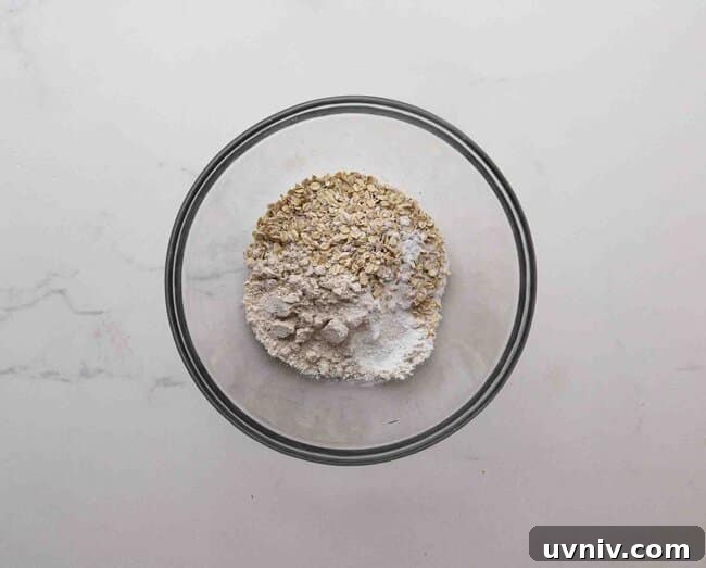 Single-Serve Oatmeal Protein Pancakes Recipe 4 Oats, oat flour, and baking powder in a bowl.