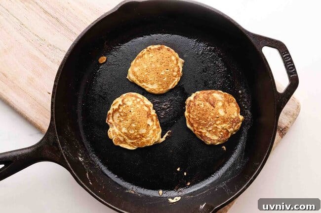 Single-Serve Oatmeal Protein Pancakes Recipe 7 Pancakes on a cast iron skillet.