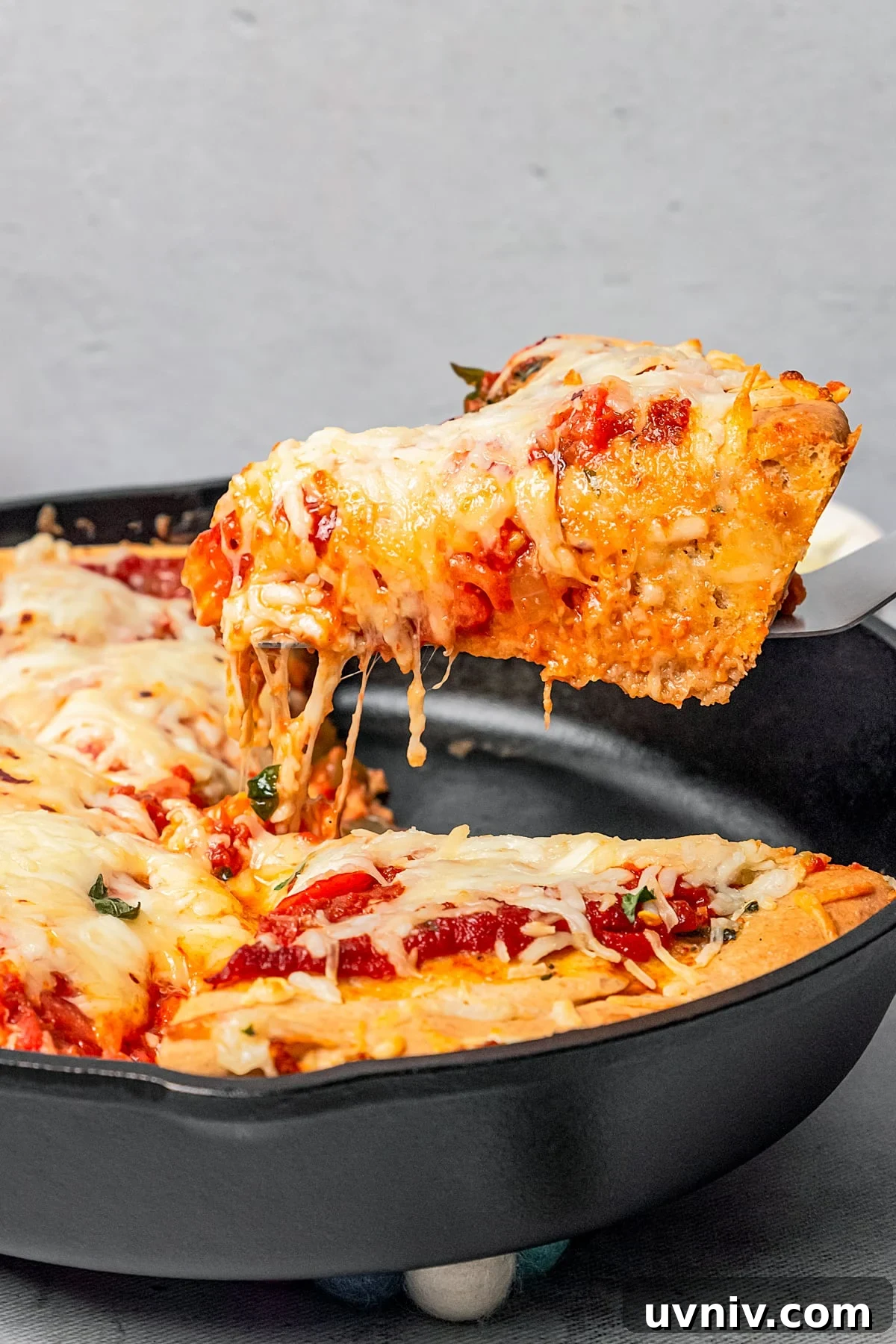 This deep dish pizza recipe with homemade herbed crust, tomatoes, and lots of melty cheese will bring Pizza Night to your kitchen each week. Lifting a slice of deep dish pizza from the skillet.