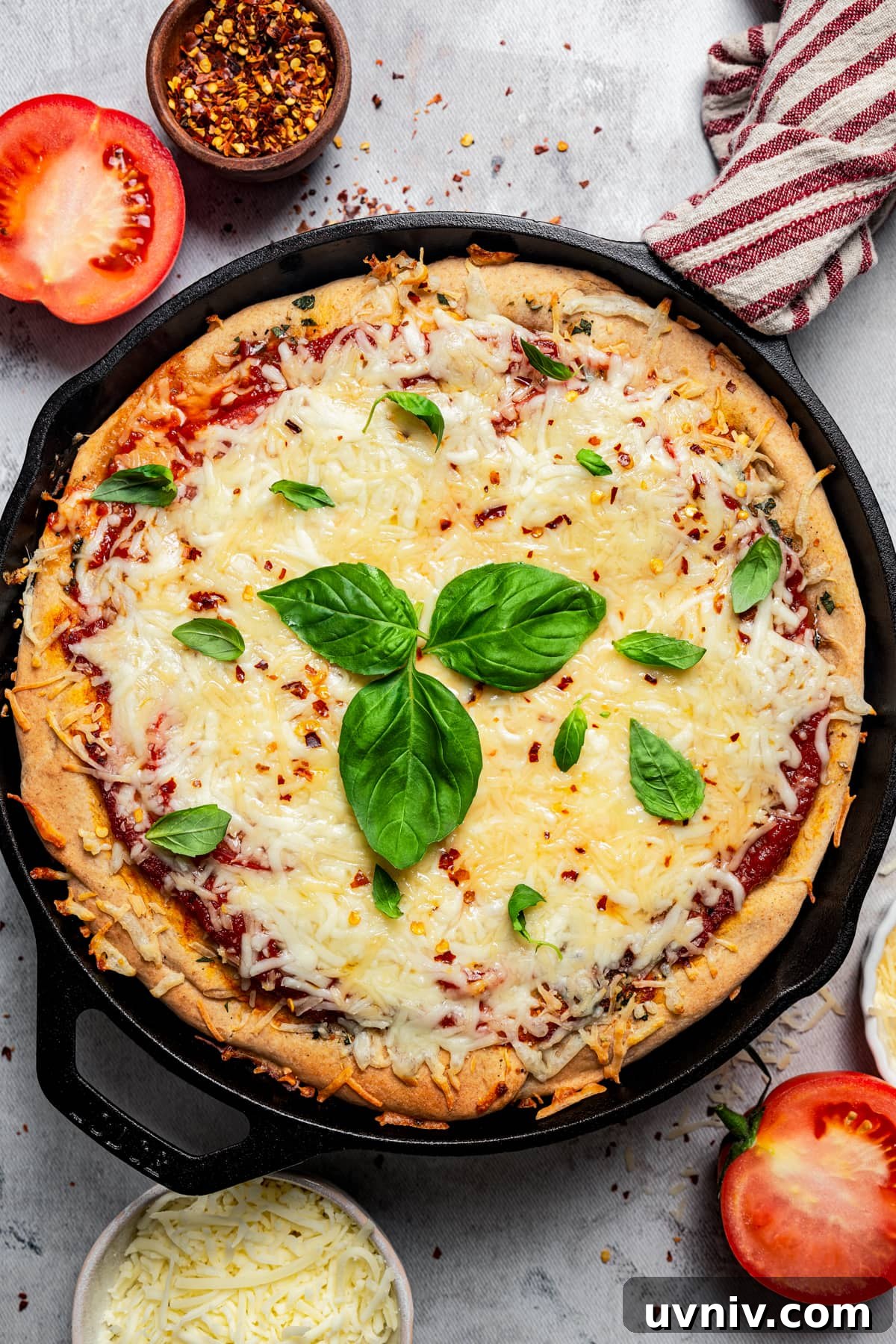 This deep dish pizza recipe with homemade herbed crust, tomatoes, and lots of melty cheese will bring Pizza Night to your kitchen each week. Whole pizza in a skillet topped with fresh basil.