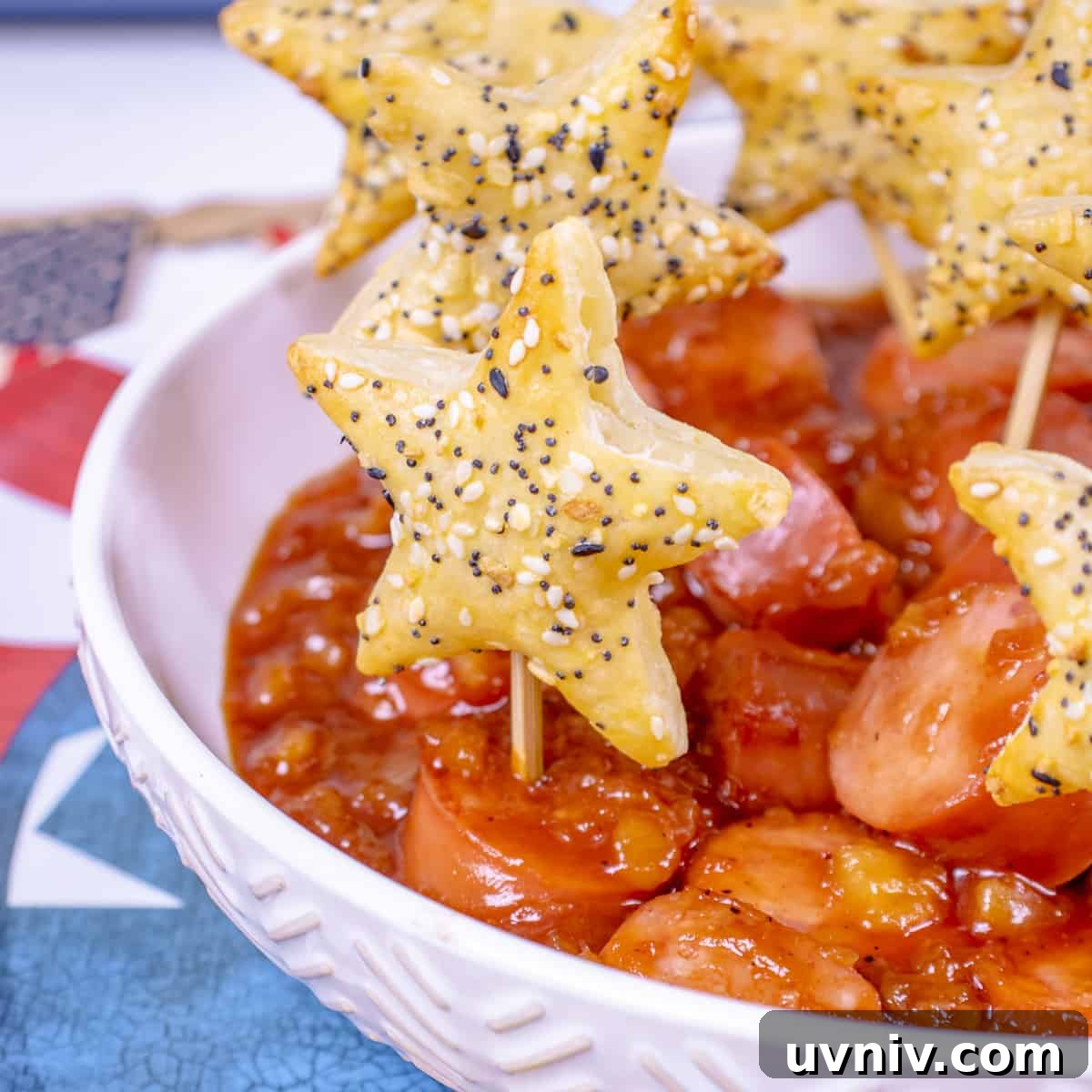 Patriotic Kielbasa Bites with Creamy Mustard Dip 5 Kielbasa sliced in bowl with sauce and toothpick stars.