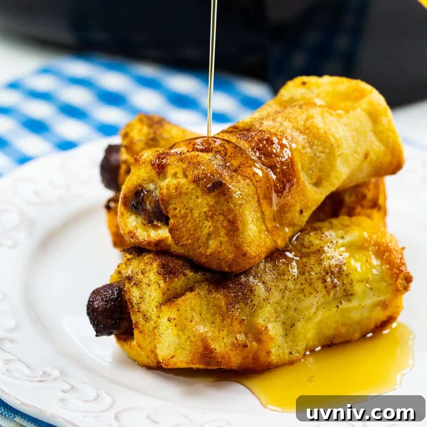 Air Fryer Sausage and French Toast Roll-Ups: Quick Breakfast Recipe 2 Three French Toast Roll-Ups on a plate getting drizzled with syrup.