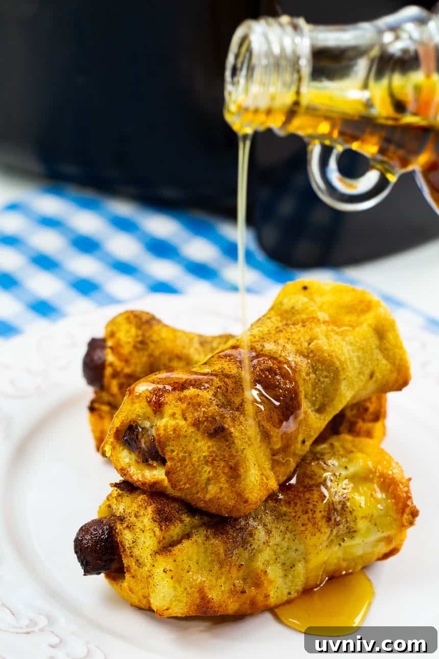Air Fryer Sausage and French Toast Roll-Ups: Quick Breakfast Recipe 4 Drizzling maple syrup on Air Fryer French Toast Sausage Roll-Ups.