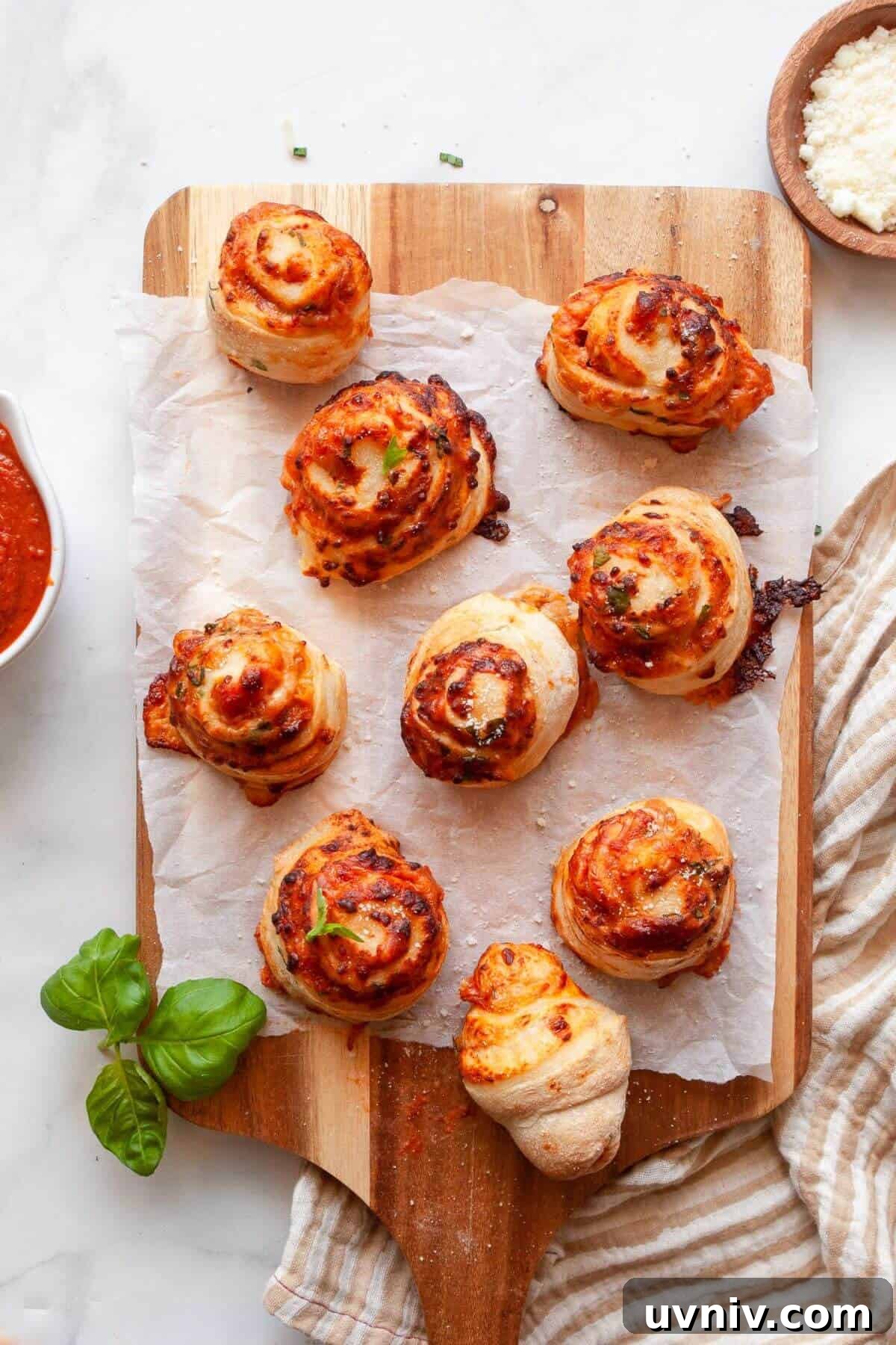 Crispy Air Fryer Pizza Rolls You Can Make at Home 9 Golden, cheesy homemade air fryer pizza rolls on a cutting board after air frying.