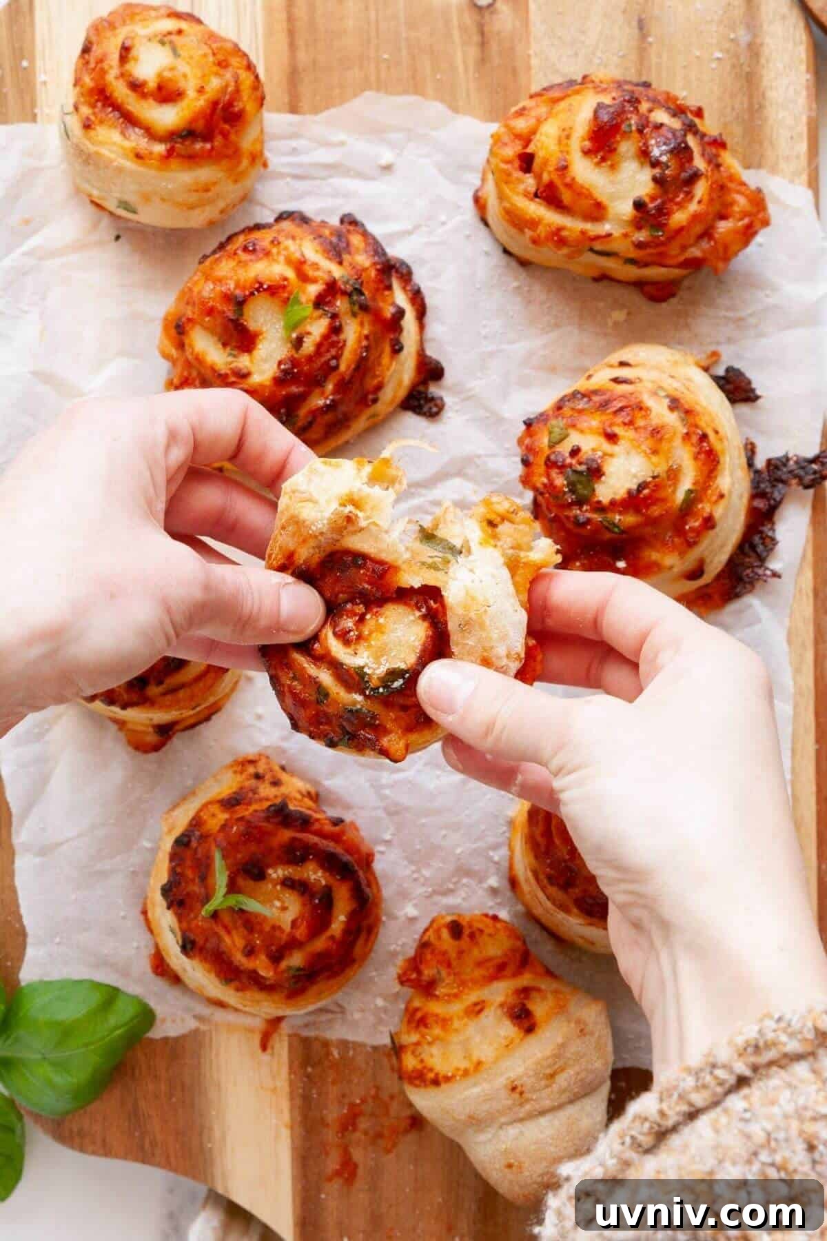 Crispy Air Fryer Pizza Rolls You Can Make at Home 10 Tearing apart a cheesy homemade air fryer pizza roll to show gooey melted mozzarella and marinara filling inside.