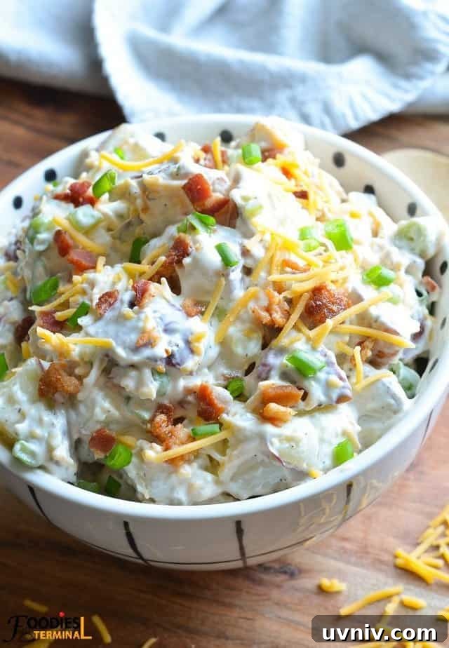 Creamy Loaded Potato Salad Made in the Instant Pot 2 loaded baked potato salad in a white bowl garnished with bacon, cheddar & green onion