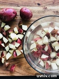 Creamy Loaded Potato Salad Made in the Instant Pot 16 diced potatoes in a bowl in water and also on a chopping board