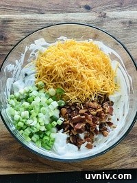 Creamy Loaded Potato Salad Made in the Instant Pot 21 crispy bacon, cheddar, green onion added to the potato dressing mixture in a bowl