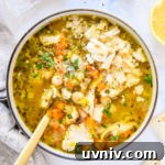 white bean lemon chicken soup in a bowl with saltine crackers on top.
