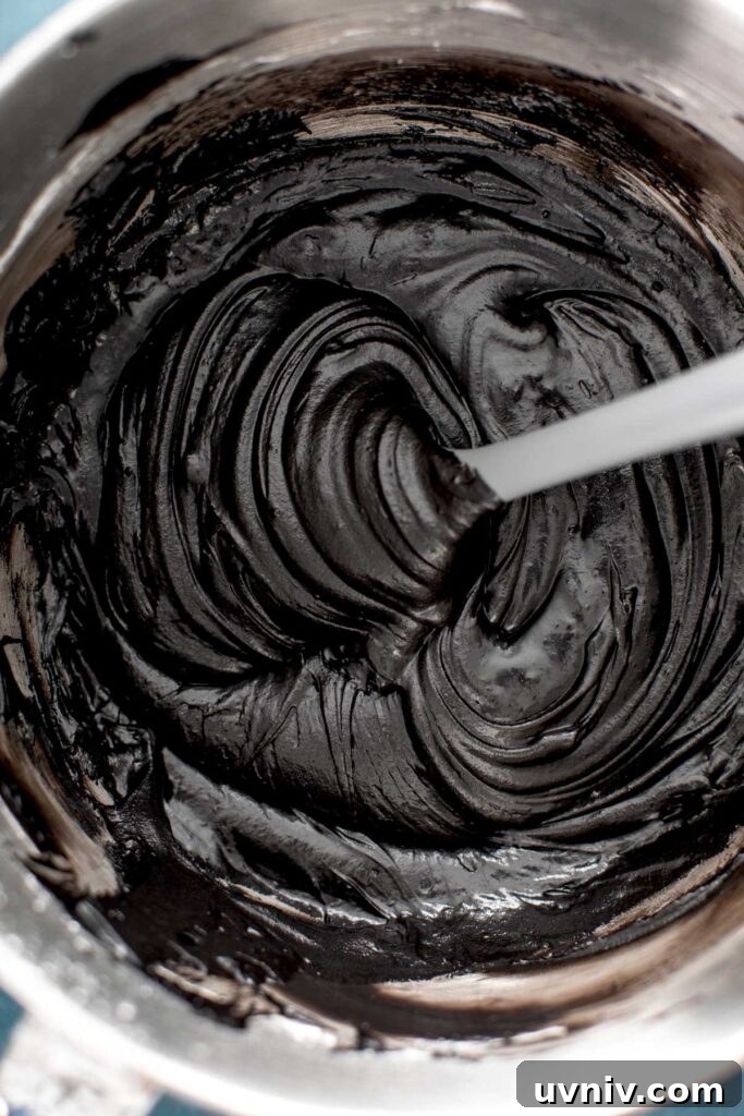 Black Cocoa frosting in a large bowl with a gray spatula.