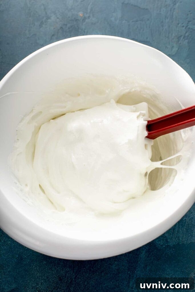 Soft and fluffy melted marshmallow in a white mixing bowl