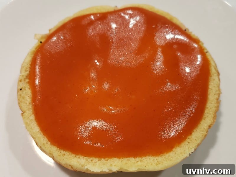 Make-Ahead Arby’s-Style Beef & Cheddar Sandwich Recipe 3 a bottom half of bun with red dressing on top
