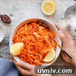 hands holding a bowl of harissa carrot salad