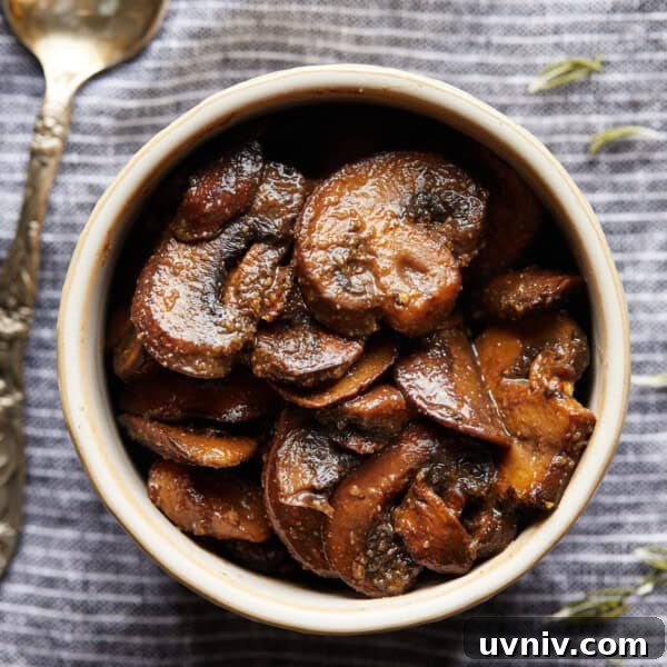 Italian Pasta Salad (No Mayo) — Fresh Mediterranean Recipe 7 Overhead photo of browned sliced mushrooms in a small bowl on a striped cloth.