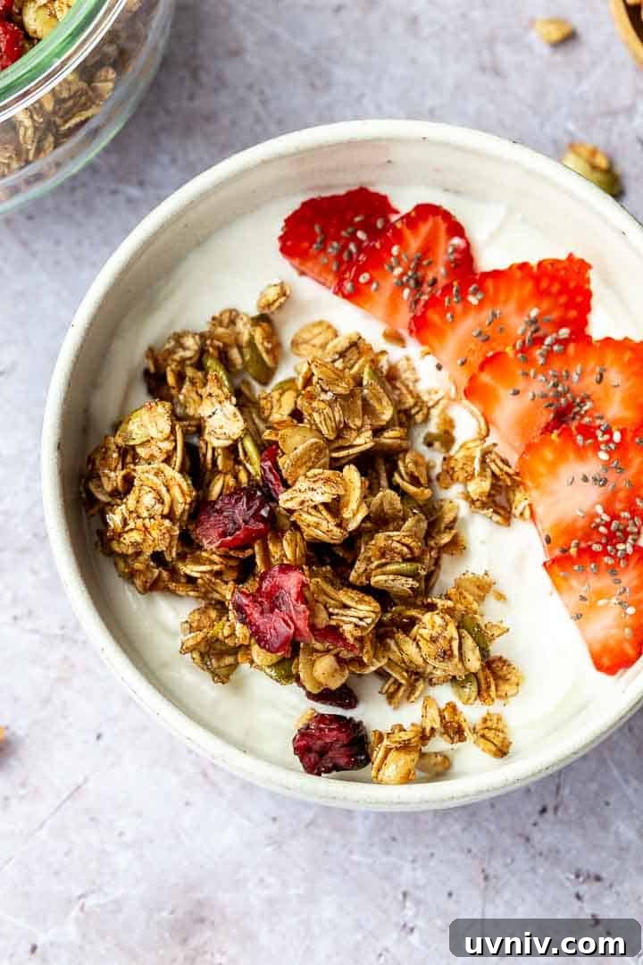 Crispy Oven-Baked Granola Without Oil: Crunchy Homemade Recipe 7 Granola and sliced strawberries over yogurt in a white bowl