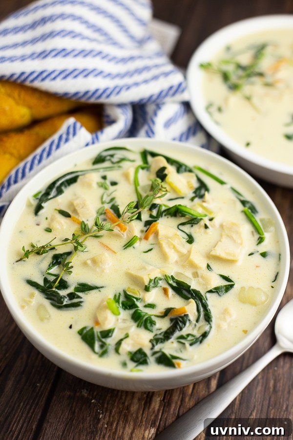 Olive Garden Chicken Gnocchi Soup Recipe (Restaurant-Style) 2 Chicken Gnocchi Soup in a white bowl with a rustic wood background and breadsticks in a white and blue striped linen behind it.