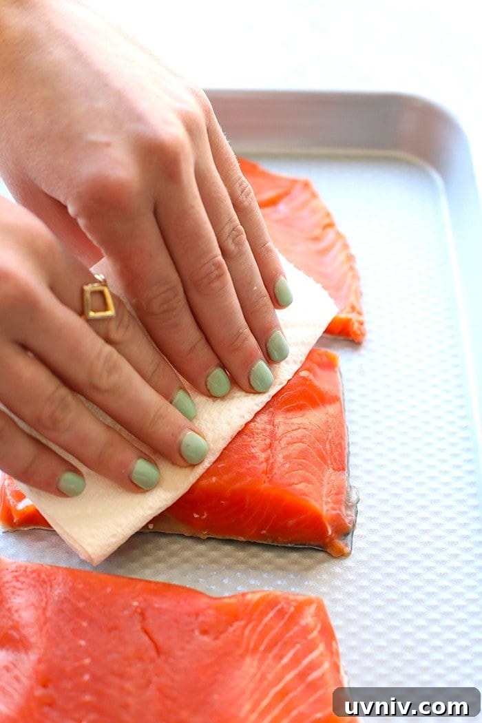 hands patting salmon fillets dry