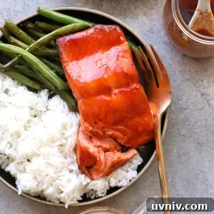 honey sriracha salmon on plate with rice and green beans and fork