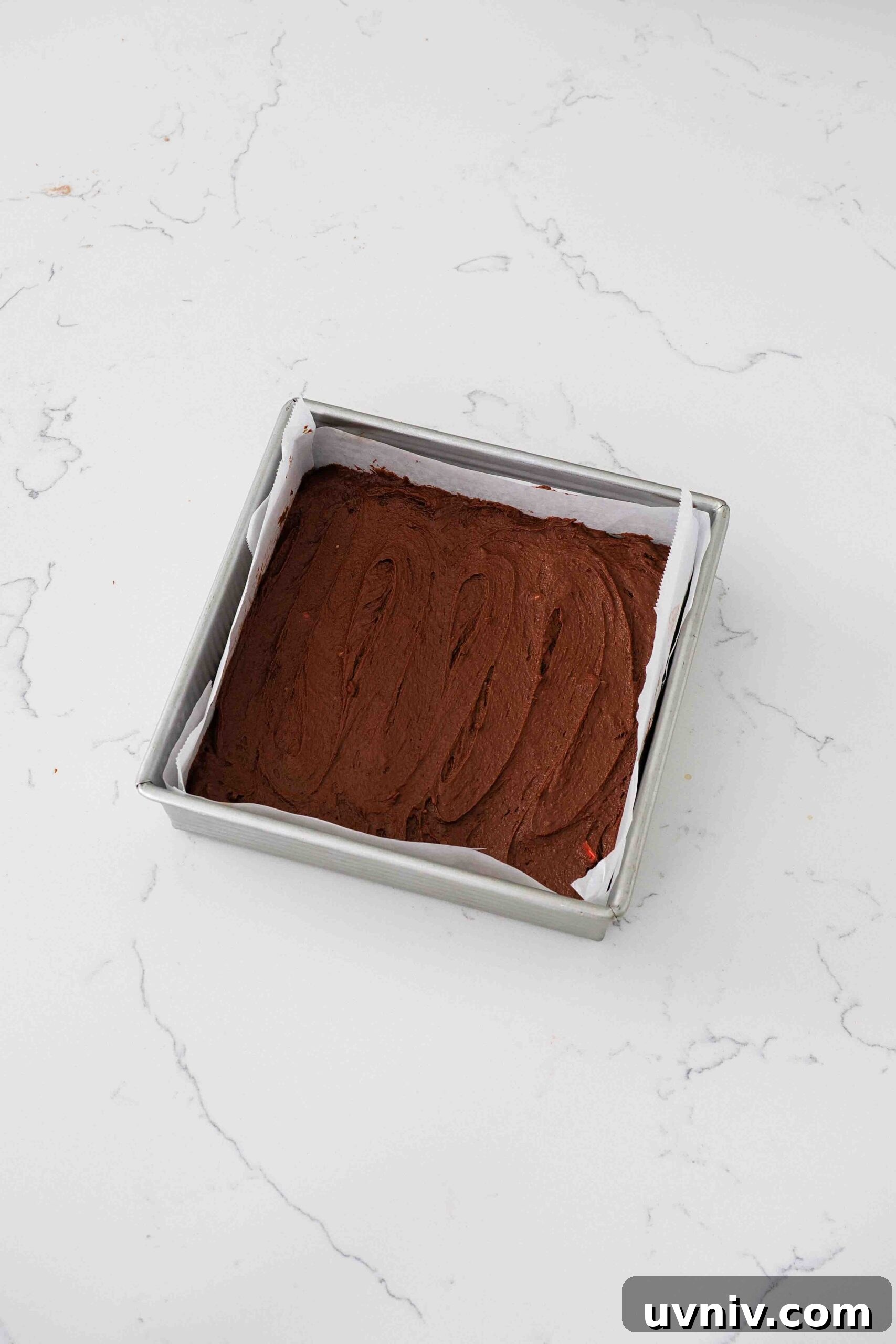 Decadent Peppermint Brownies Recipe for Holiday Baking 12 Unbaked peppermint brownies in a square pan.