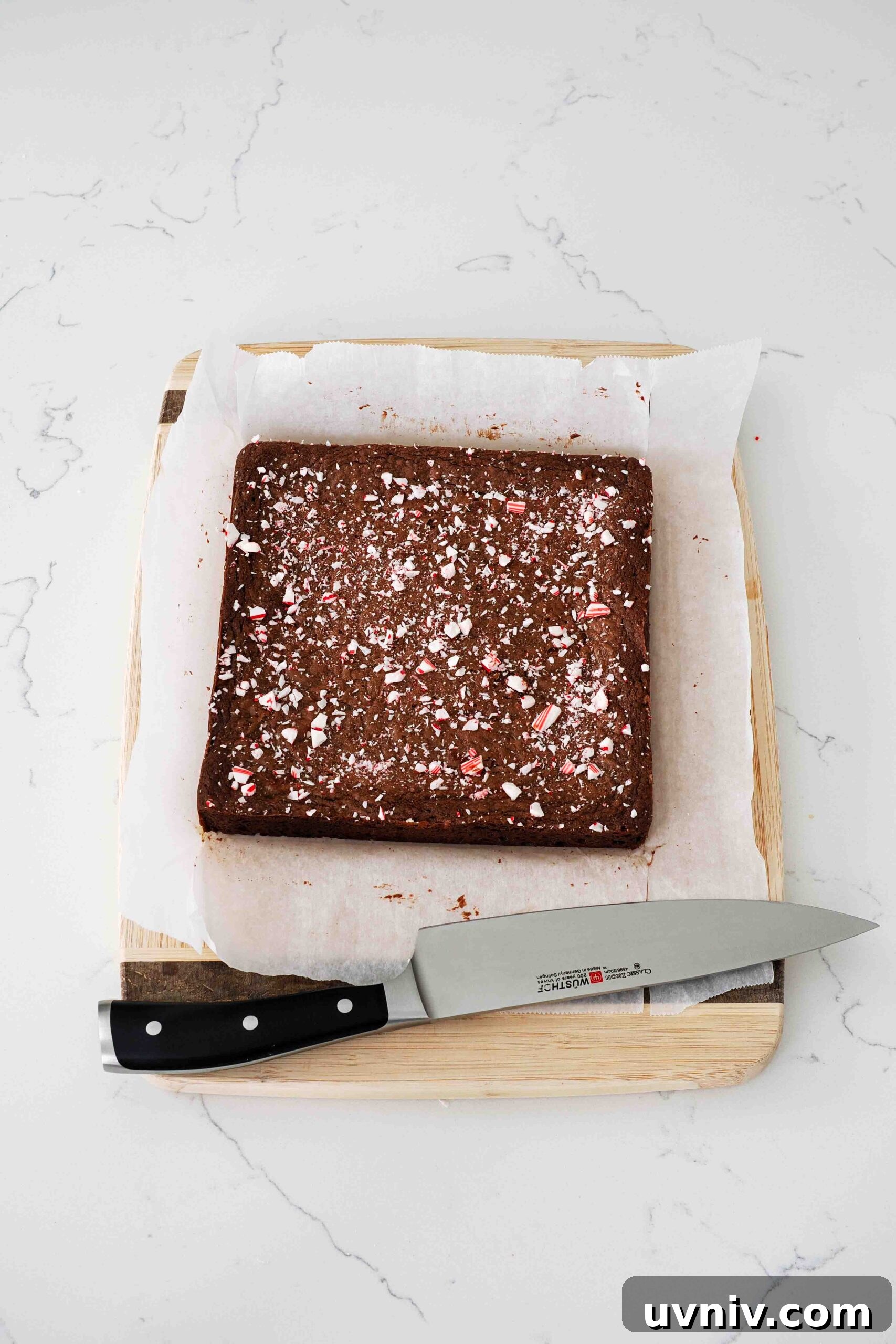 Decadent Peppermint Brownies Recipe for Holiday Baking 14 A slab of candy cane brownies cooling on a cutting board.