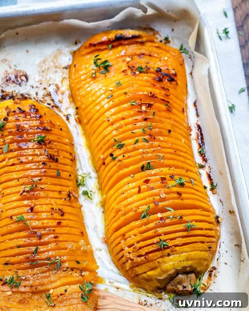 Crispy Hasselback Butternut Squash with Herb Butter 3 close up side shot of two Hasselback butternut squash on a baking pan