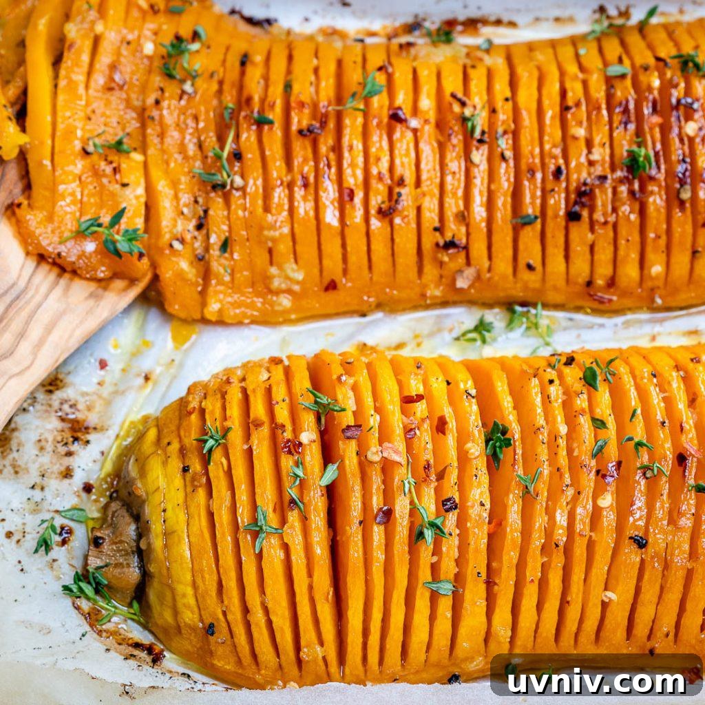 Crispy Hasselback Butternut Squash with Herb Butter 7 close up of sliced butter nut squash roasted on a pan