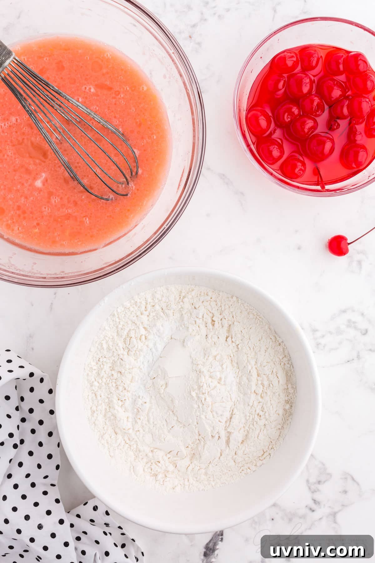 cherry juice mixture with spatula next to bowl of cherries and bowl of flour for cherry bread.