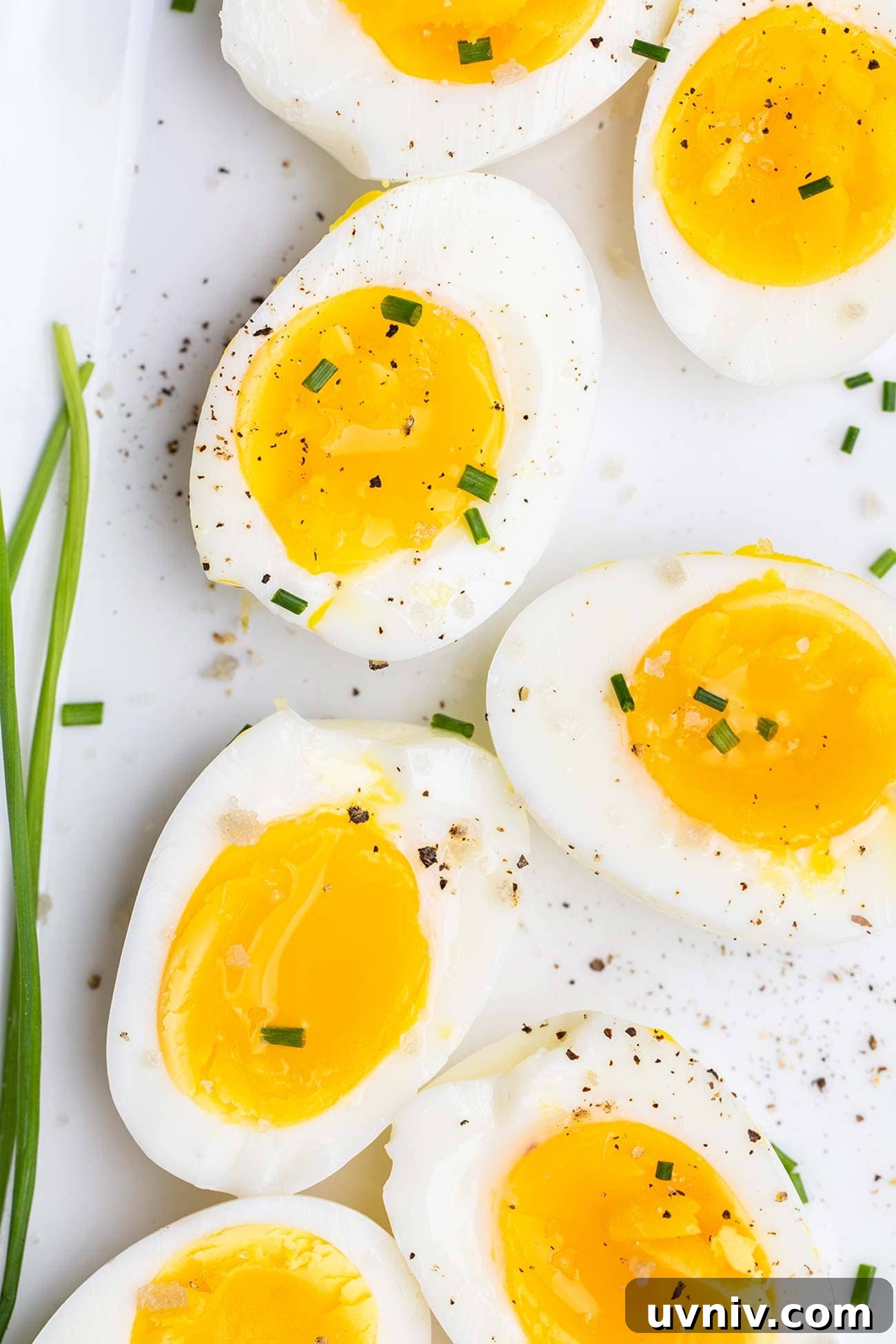 Perfect Air Fryer Hard-Boiled Eggs That Peel Easily 2 Perfect soft boiled eggs shown on a plate garnished with chives.