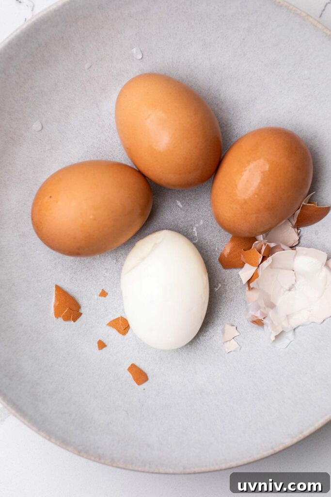 Perfect Air Fryer Hard-Boiled Eggs That Peel Easily 7 Eggs in a bowl showing the shell peeling off easily.