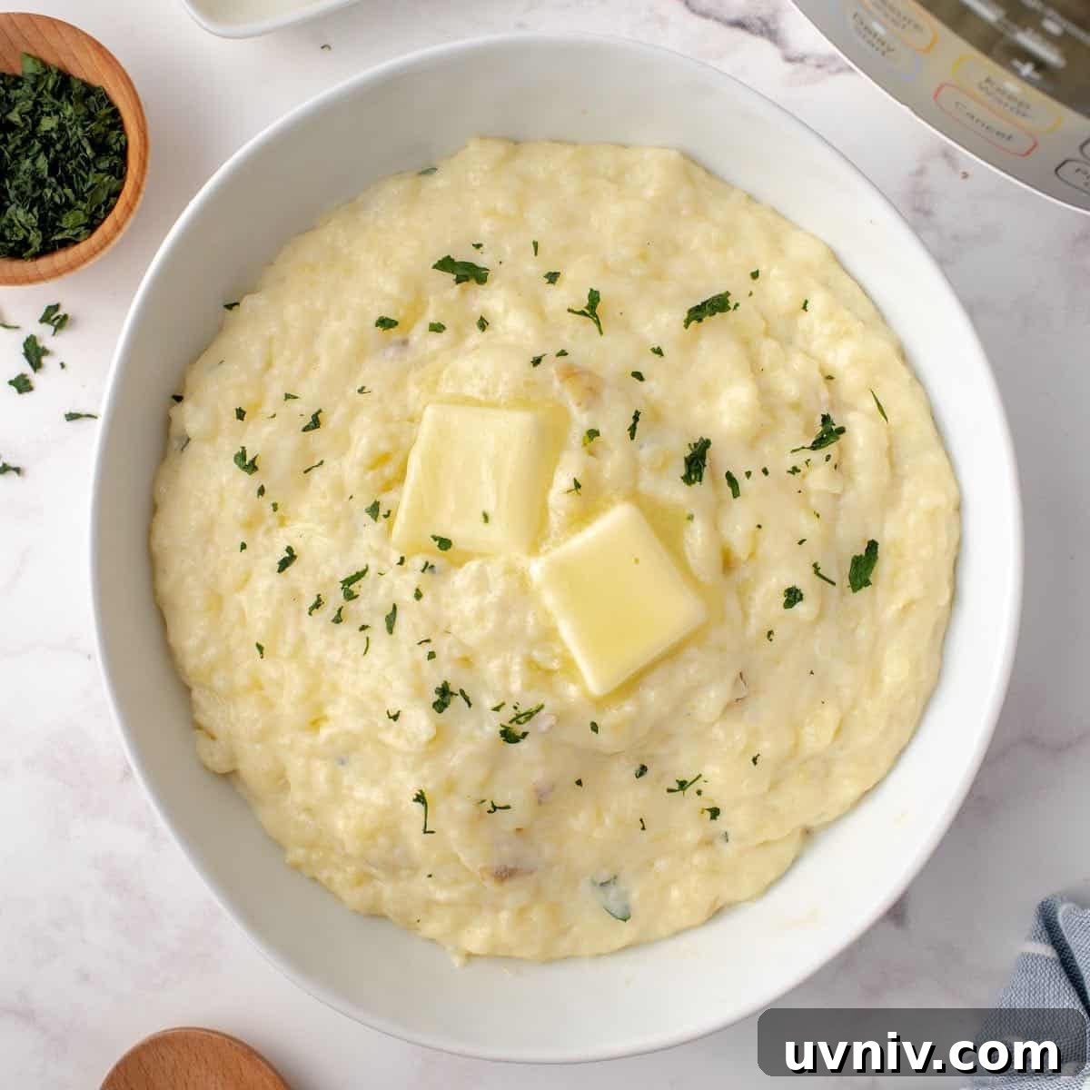 Mashed potatoes in a bowl topped with butter.