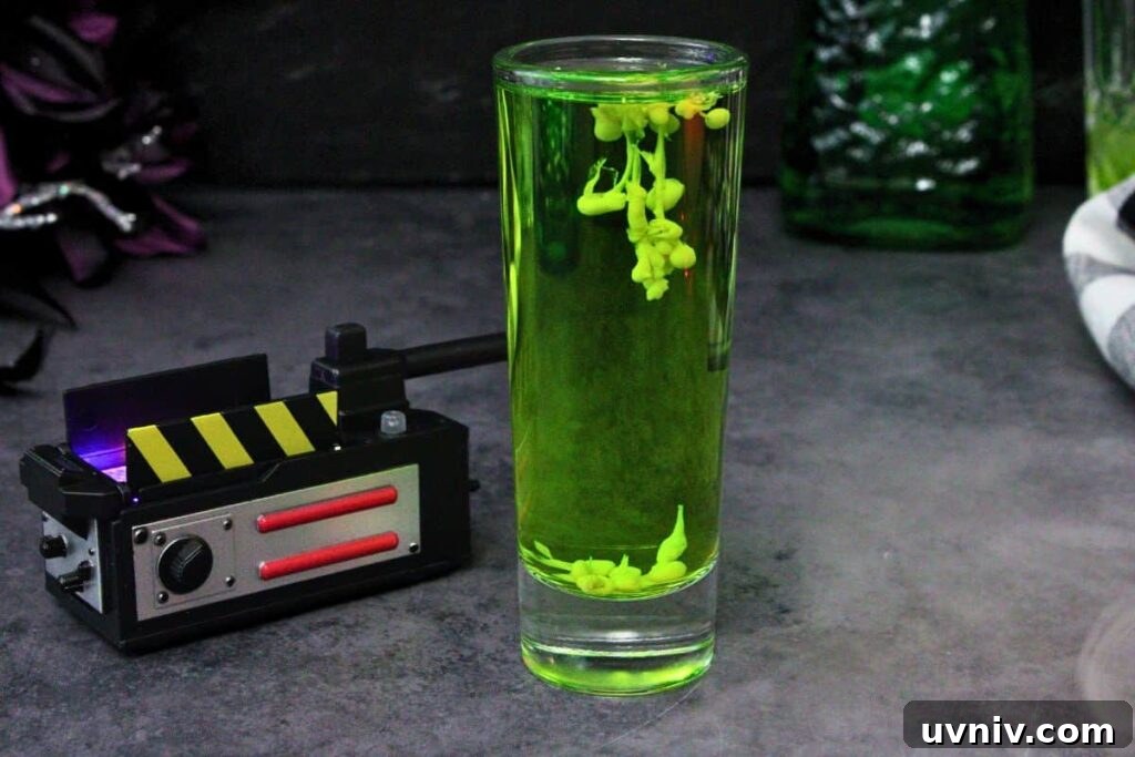 Slimer Ghostbusters Shot Recipe for a Spooky Halloween Party 8 tall ghostbusters shot with green slimer ectoplasm next to an open ghost trap on a dark background with fog