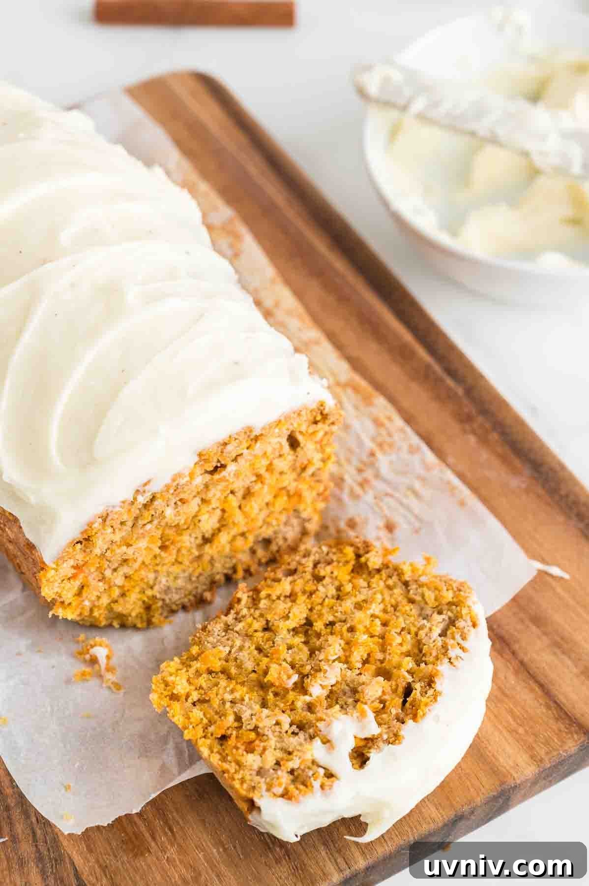 Moist Carrot Cake Loaf with Cream Cheese Glaze 2 An image of carrot cake loaf with a slice taken from it.