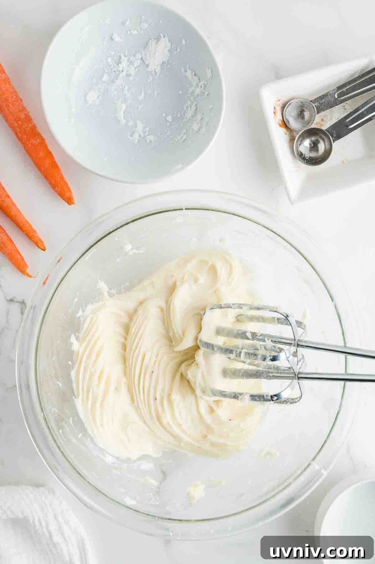 Moist Carrot Cake Loaf with Cream Cheese Glaze 11 An overhead image of whipping the frosting with a handheld mixer.