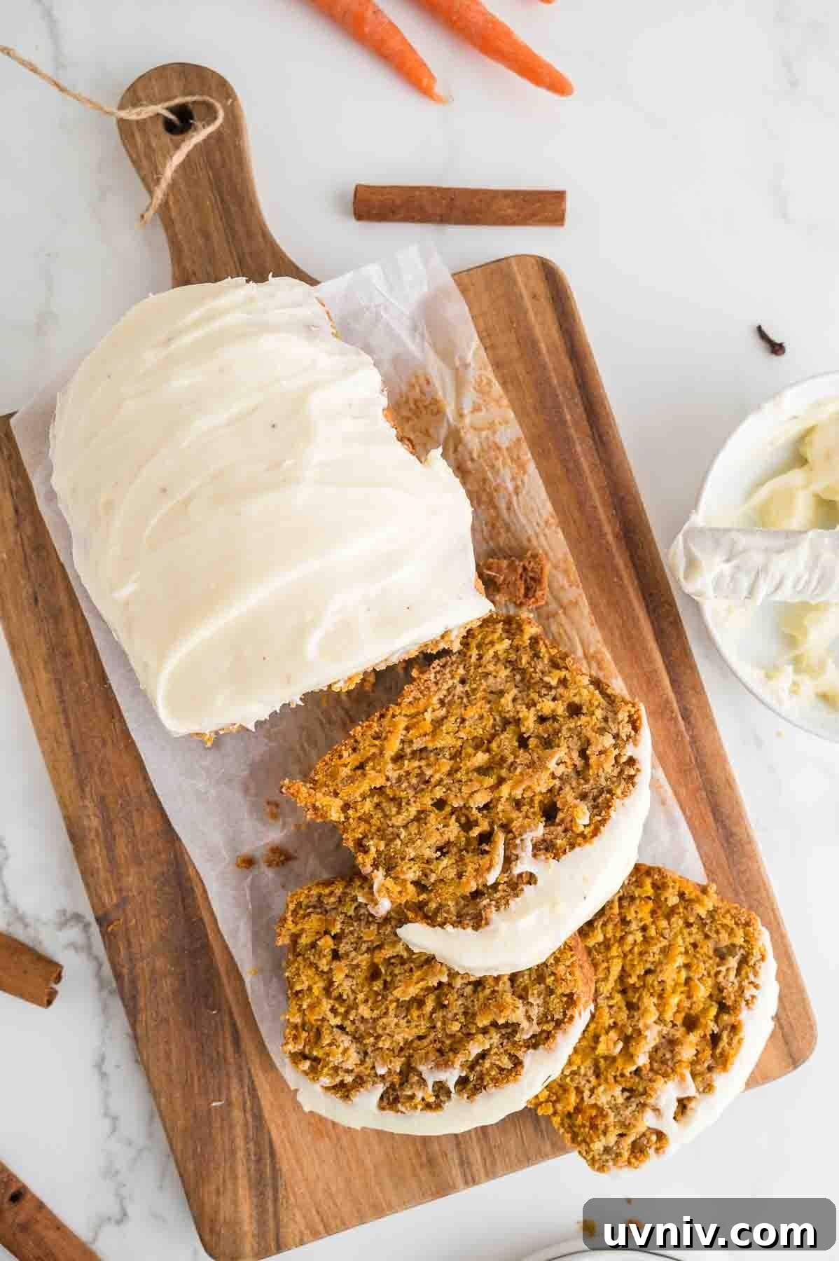 Moist Carrot Cake Loaf with Cream Cheese Glaze 12 An overhead image of the carrot cake loaf with half of it sliced.