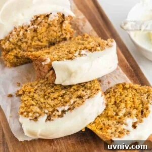 Moist Carrot Cake Loaf with Cream Cheese Glaze 18 A close up image of carrot cake slices on a wooden board.