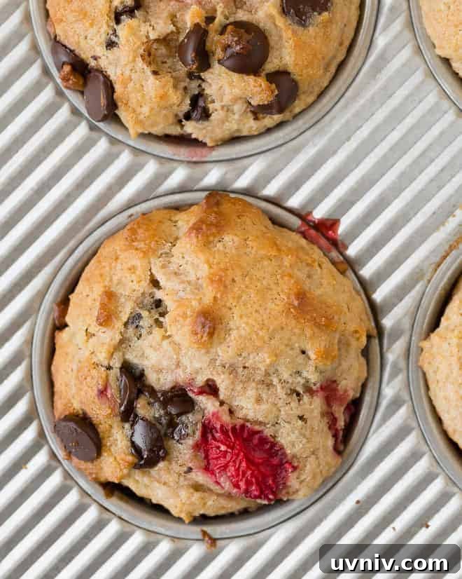 Strawberry Chocolate Chip Muffins Recipe — Moist Summer Muffins 3 Overhead image of a strawberry muffin with chocolate chips in a baking tin.