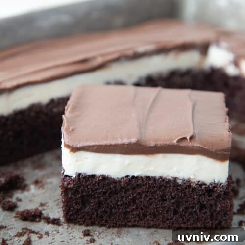 slice of ding dong cake in a cake pan with more ding dong cake in the pan.