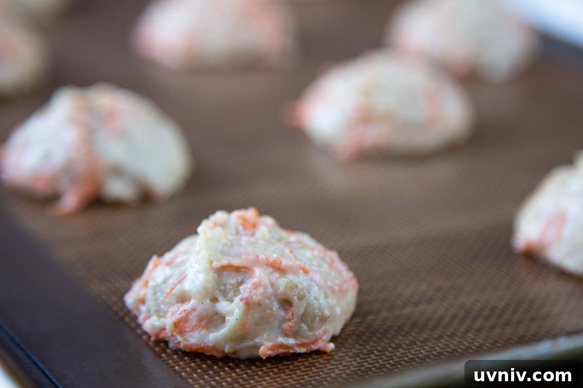 Carrot Cake Whoopie Pies Recipe: Soft Spiced Sandwich Cookies 4 unbaked cake batter mounds on a baking sheet.