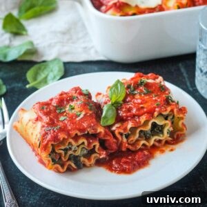 Two lasagna roll ups on a white plate garnished with fresh basil.